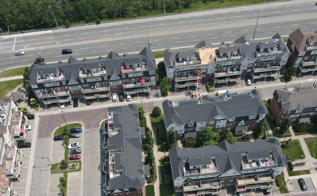 Aerial view of townhouse roofs with active roofing work by The Roofers, ideal for property managers seeking roof repair and maintenance services in Vaughan, Mississauga, and surrounding GTA areas.